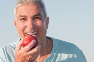 Man happily eating an apple