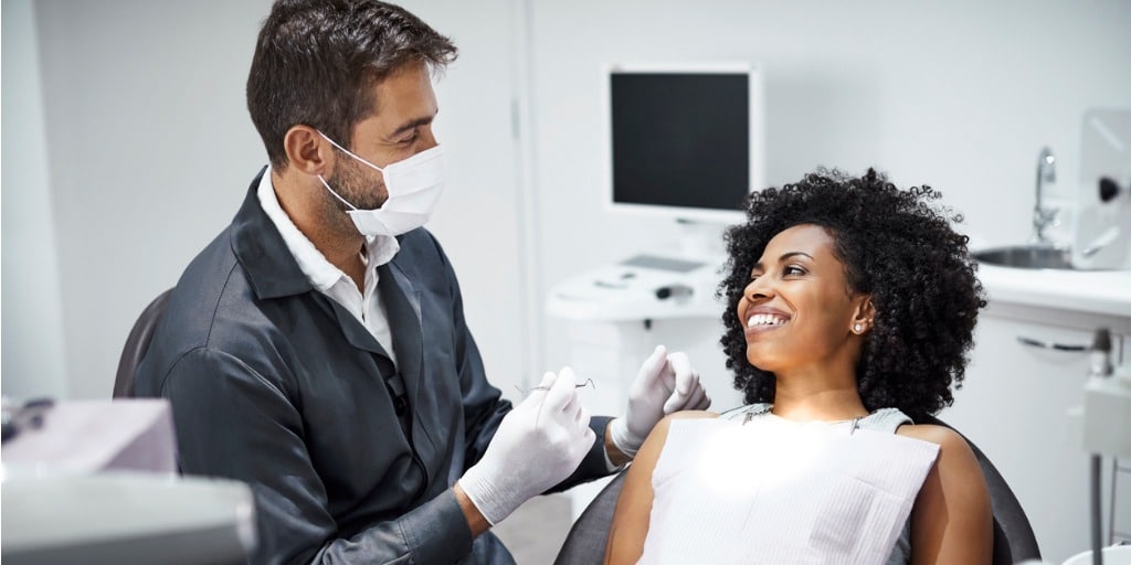 dentist examining smiling female patient in clinic picture id1199167313