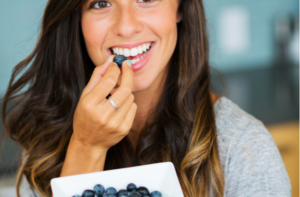 Beautiful woman eating blueberries