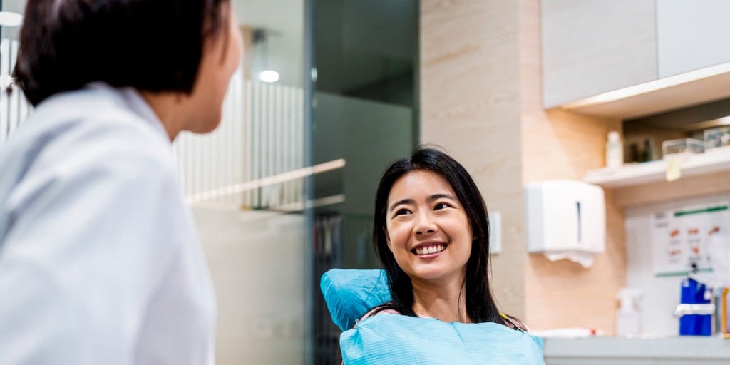 smiling patient looking at dentist in clinic picture id1158808108 1