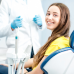 woman with toothy smile sitting at the dental chair w