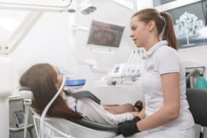 Dentist talking to her patient after putting inhalation sedation face mask on her